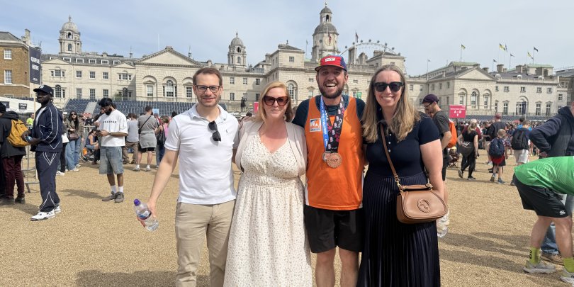 Adam Blackmore-Heal, pictured with his supporters while wearing an orange Brooke vest and runners medal, ran this year's London Marathon for Brooke.