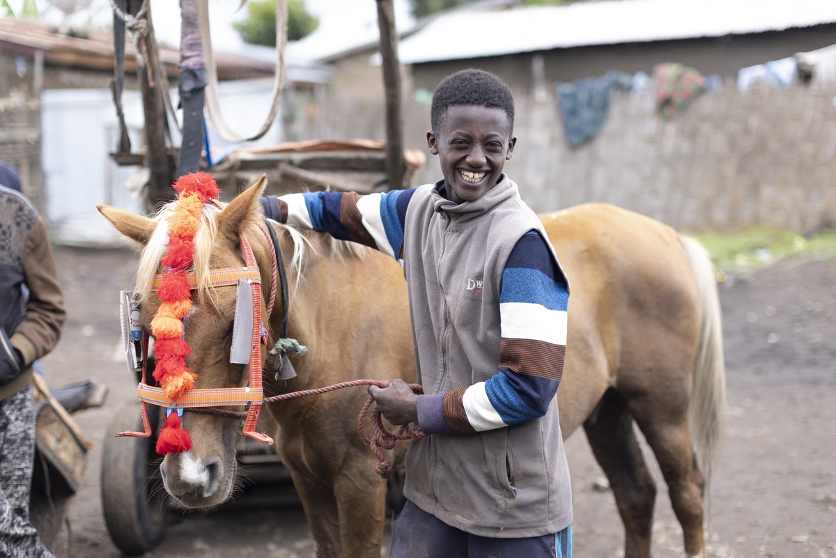 Boy hugging horse in Ethiopia