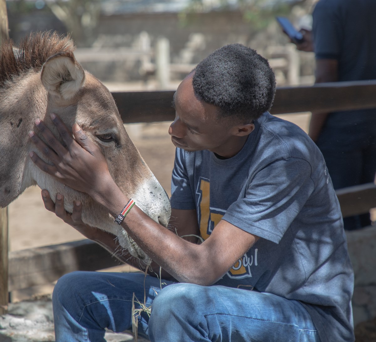 Man embraces donkey in Kenya.