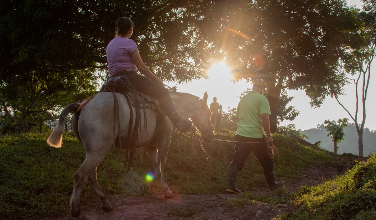 Woman rides horse led by man in Nicaragua