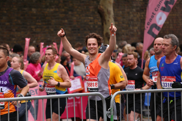 Man smiling to camera whilst running marathon