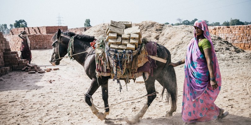 woman working with horse at a brick kiln