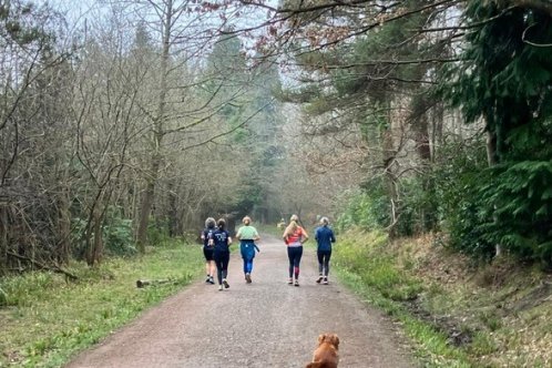 Four women running in the forest