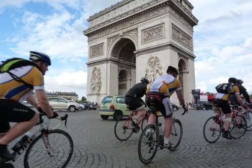 Cyclists pass the Arc de Triomphe