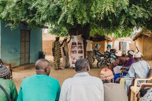 Three men presenting to a group using a poster about equine welfare 