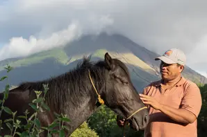 Man stand with pony in front of mountain