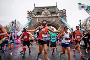 Joey wears a grey and orange Brooke running top as he leads a race outdoors