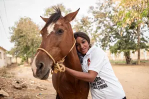 Woman farrier stands with horse