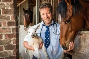 Julian Norton holding lamb next to horse