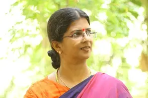 Padmapriya stands in front of trees