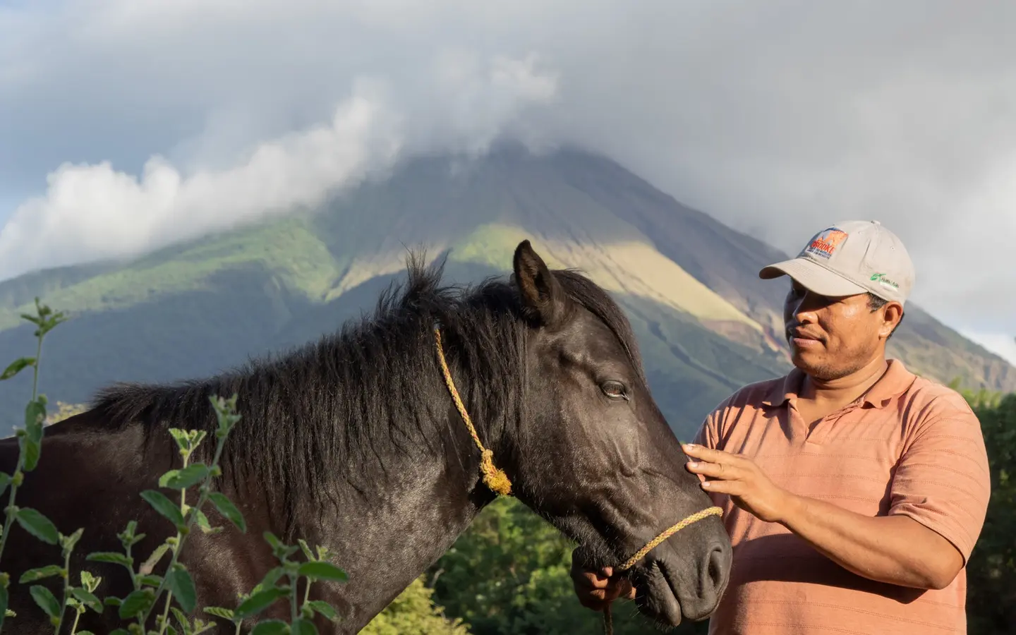 Man stand with pony in front of mountain