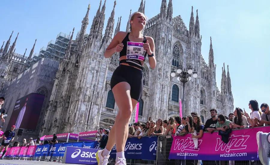 Woman running marathon in front of Duomo di Milano