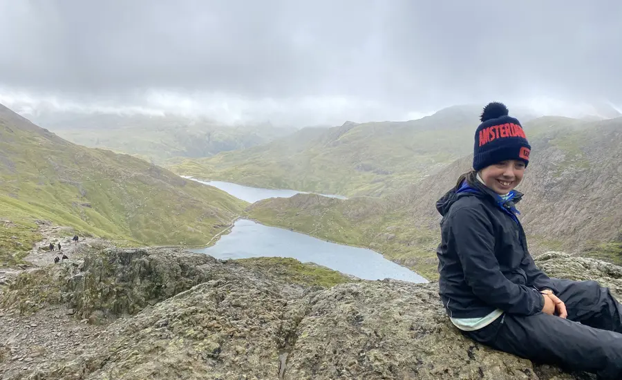 Young girl on wall overlooking mountain