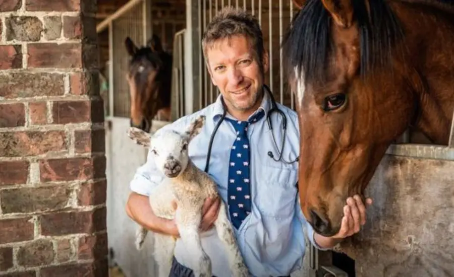 Julian Norton holding lamb next to horse