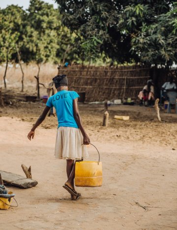 A girl carries a bucket of water in Senegal A girl carries a bucket of water in Senegal