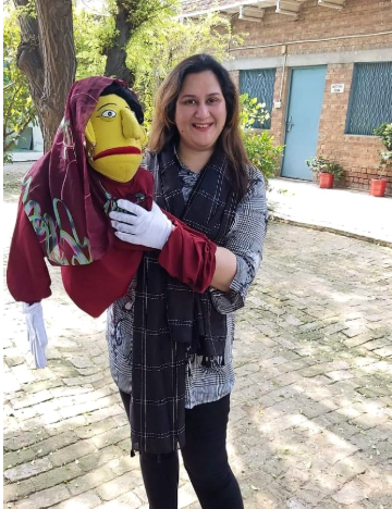 Sana organising the TOT (training of trainers) for the community development team, using a puppet's performance to demonstrate changing equine owners' behaviour Woman holding a puppet in Pakistan