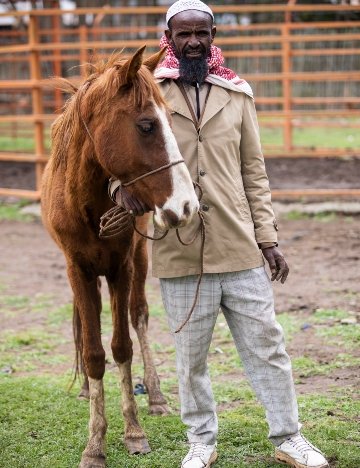 Wako standing with one of his horses