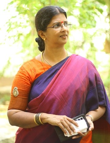 Padmapriya stands in front of trees