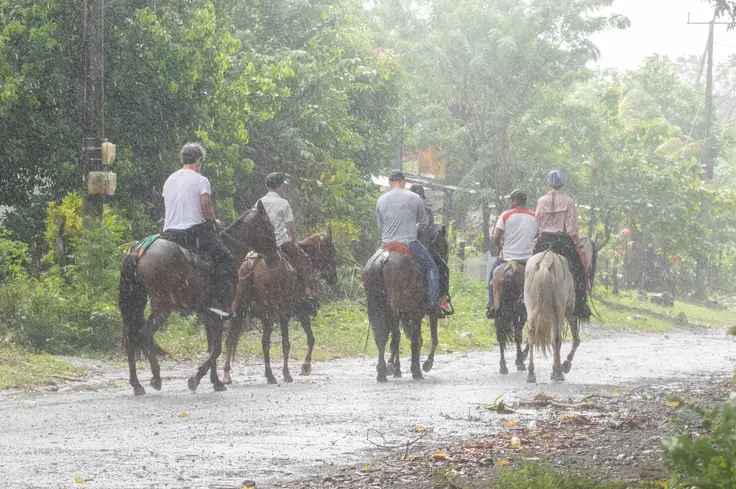Tourists riding horses through rain in Nicaragua
